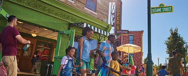 Family walking outside Hoopers Store at Sesame Street Land